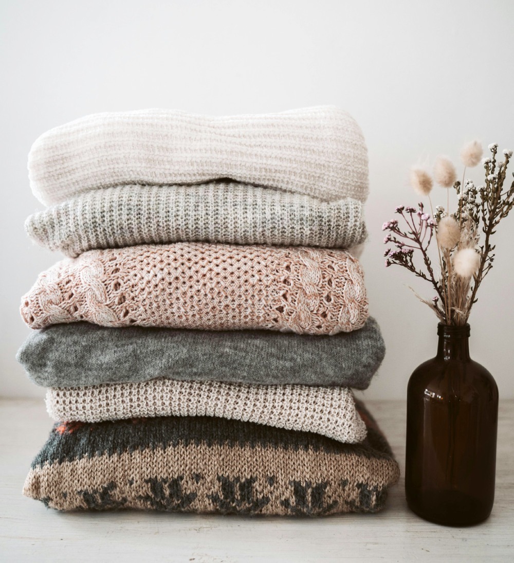 Ein ordentlicher Stapel warmer, gestrickter Pullover aus Wolle.