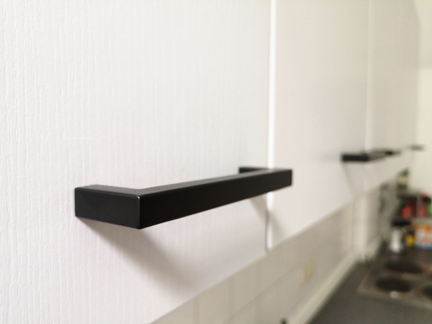 Neue schwarze Handgriffe frischen eine Kueche auf.