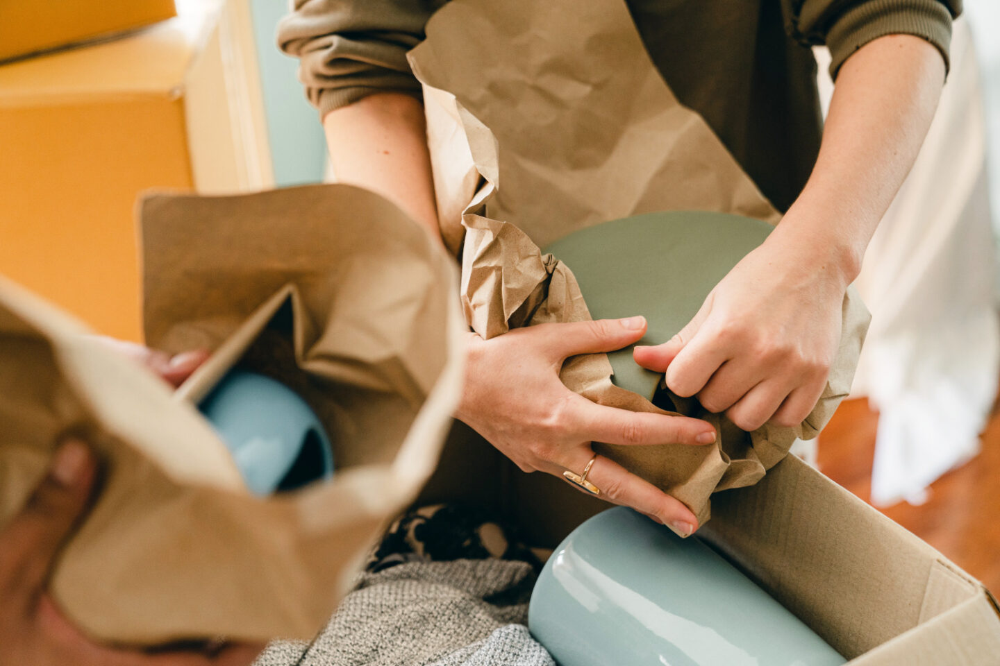 Dishes are wrapped in paper and stowed in moving boxes